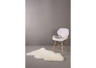 weißer Fellteppich vor weißem Stuhl